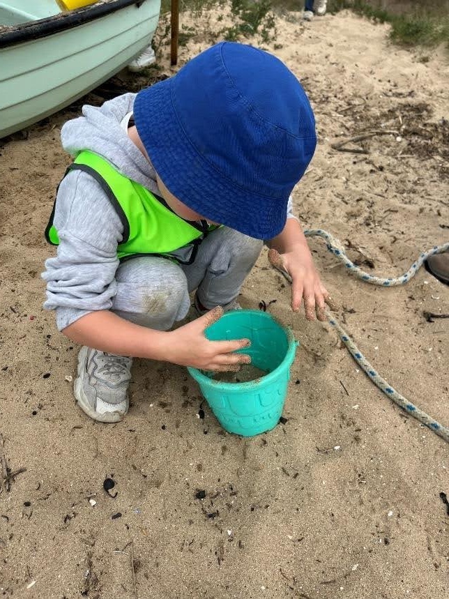 Child playing with bucket in sand
